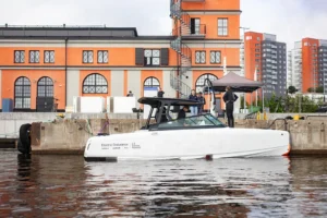 A side view of the Candela electric boat charging at the dock