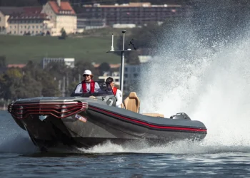 Two men ride a RIB across a lake